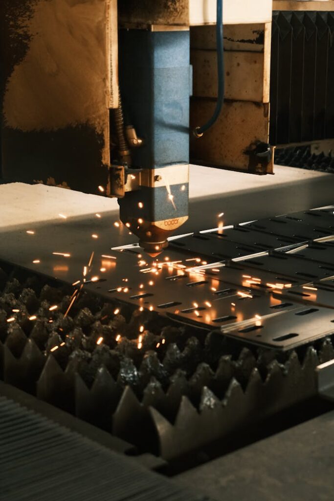 Close-up of a laser cutter in action, producing sparks in a modern manufacturing facility.